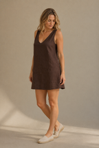 Dark brown linen shift mini dress, three-quarter view, loose fit and mini length