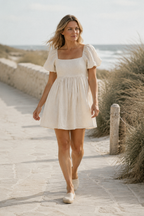 Ivory linen a-line mini dress, lifestyle, warm afternoon, sunlit courtyard