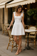 White linen a-line mini dress, front view, square neckline and shoulder ties