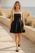Black linen a-line mini dress, lifestyle, afternoon light by a window