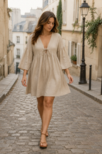 Beige linen a-line mini dress, front view, deep V-neckline with tie closure