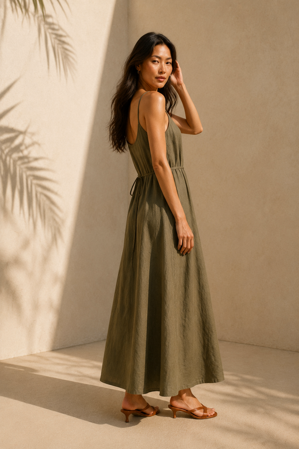 Olive green linen slip maxi dress, three-quarter view, flowing linen skirt and tie detail