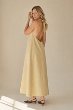 Pale yellow linen shift maxi dress, three-quarter view, flowing silhouette and floor-length hem