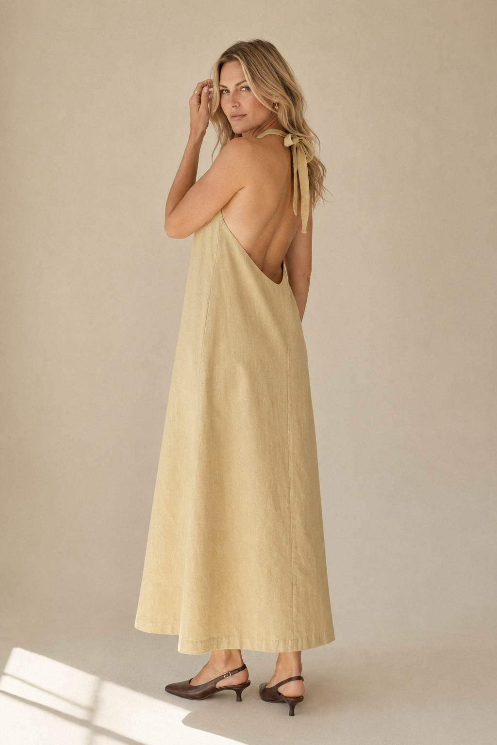 Pale yellow linen shift maxi dress, three-quarter view, flowing silhouette and floor-length hem