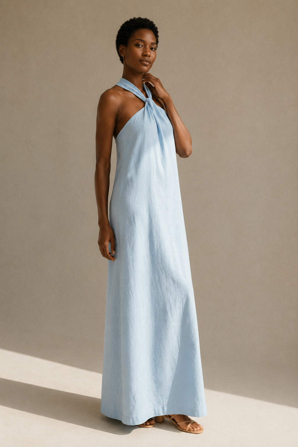Light blue linen shift maxi dress, three-quarter view, fluid skirt and halter neck detail