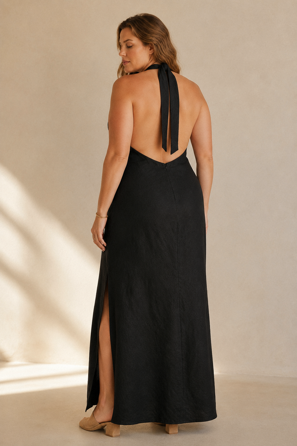 Black linen column maxi dress, back view, halter tie and deep open back