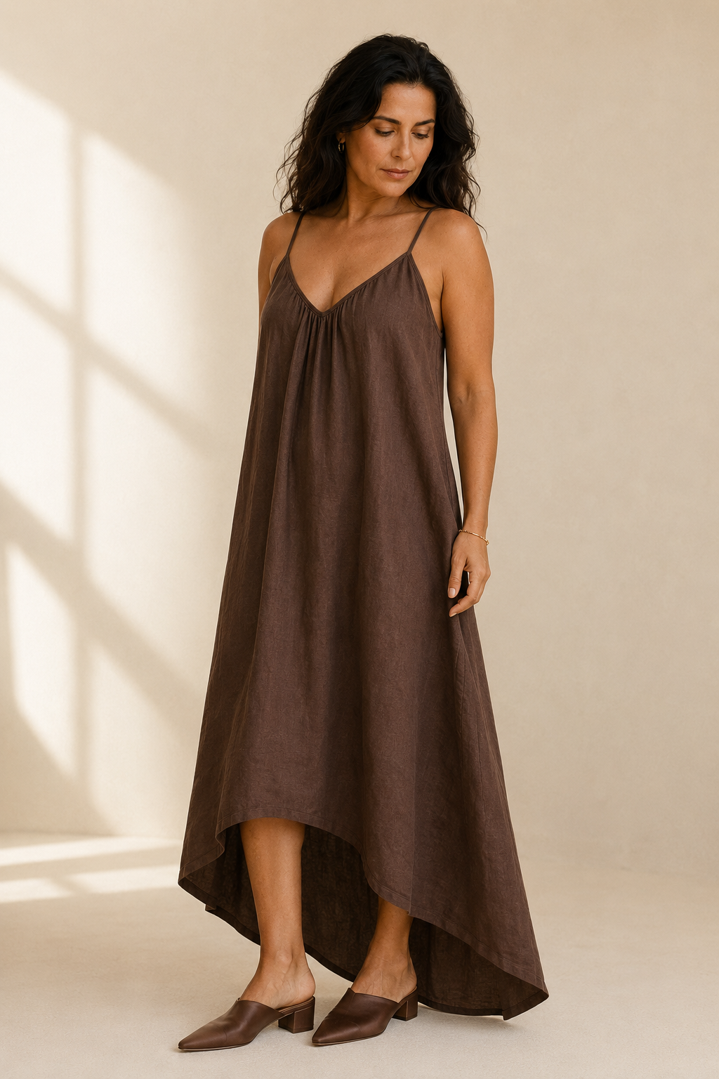 Brown linen slip maxi dress, three-quarter view, fluid silhouette and asymmetrical hemline