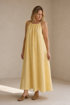 Pale yellow linen shift maxi dress, three-quarter view, soft fabric drape, full length
