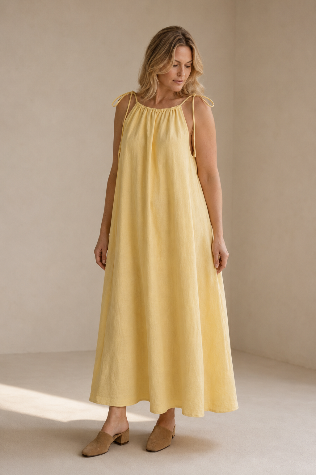 Pale yellow linen shift maxi dress, three-quarter view, soft fabric drape, full length