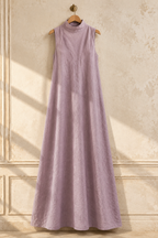 Lavender linen shift maxi dress, hanging on wooden hanger against plaster wall