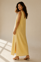 Butter yellow linen shift maxi dress, three-quarter view, side slit and natural drape