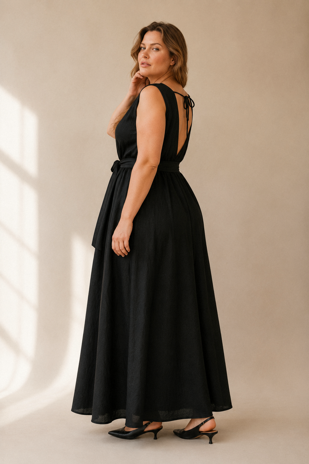 Black linen trapeze maxi dress, three-quarter view, flowing maxi length, wide hem