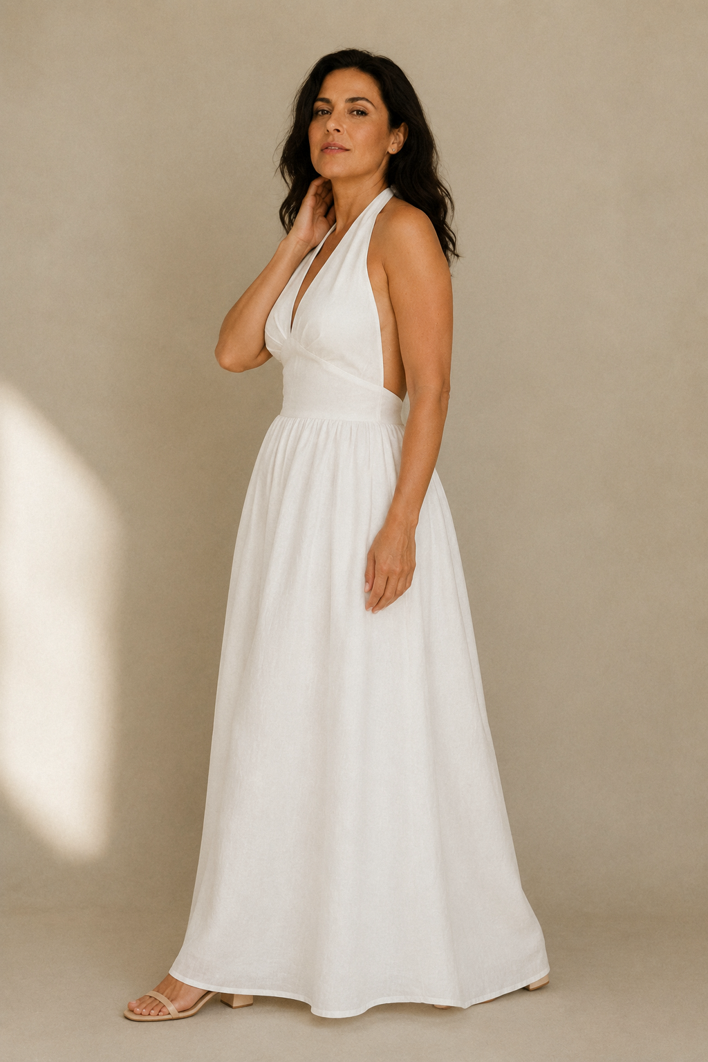White linen a-line maxi dress, three-quarter view, flowing skirt and cinched waist