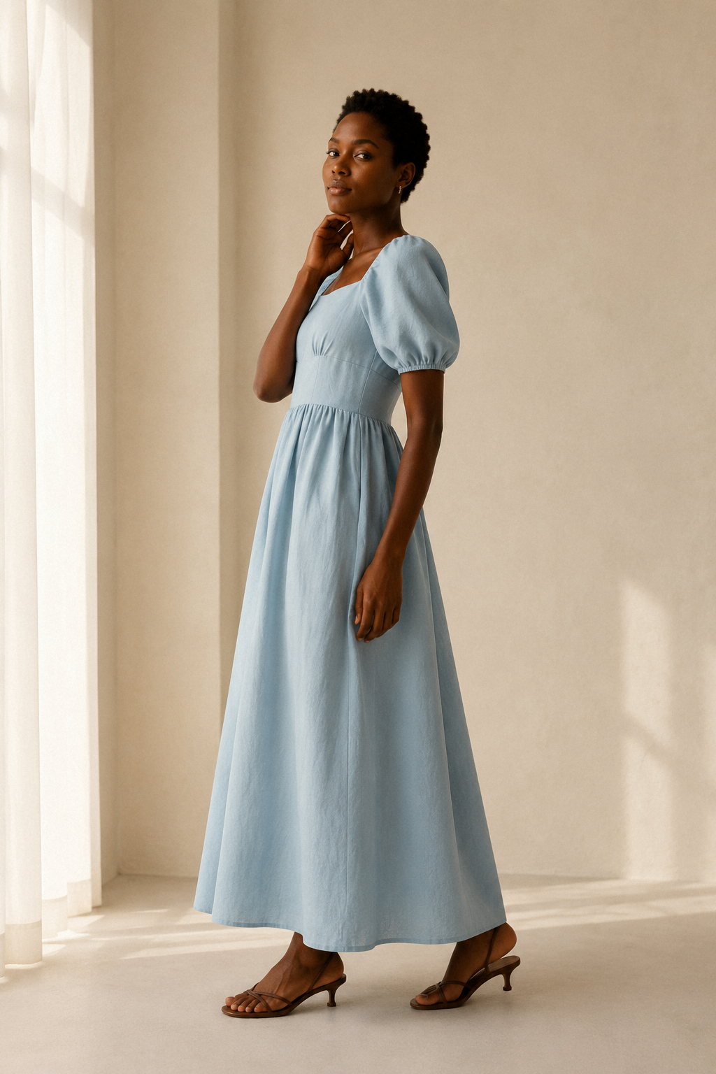 Light blue linen a-line maxi dress, three-quarter view, puff sleeves and a flowing skirt