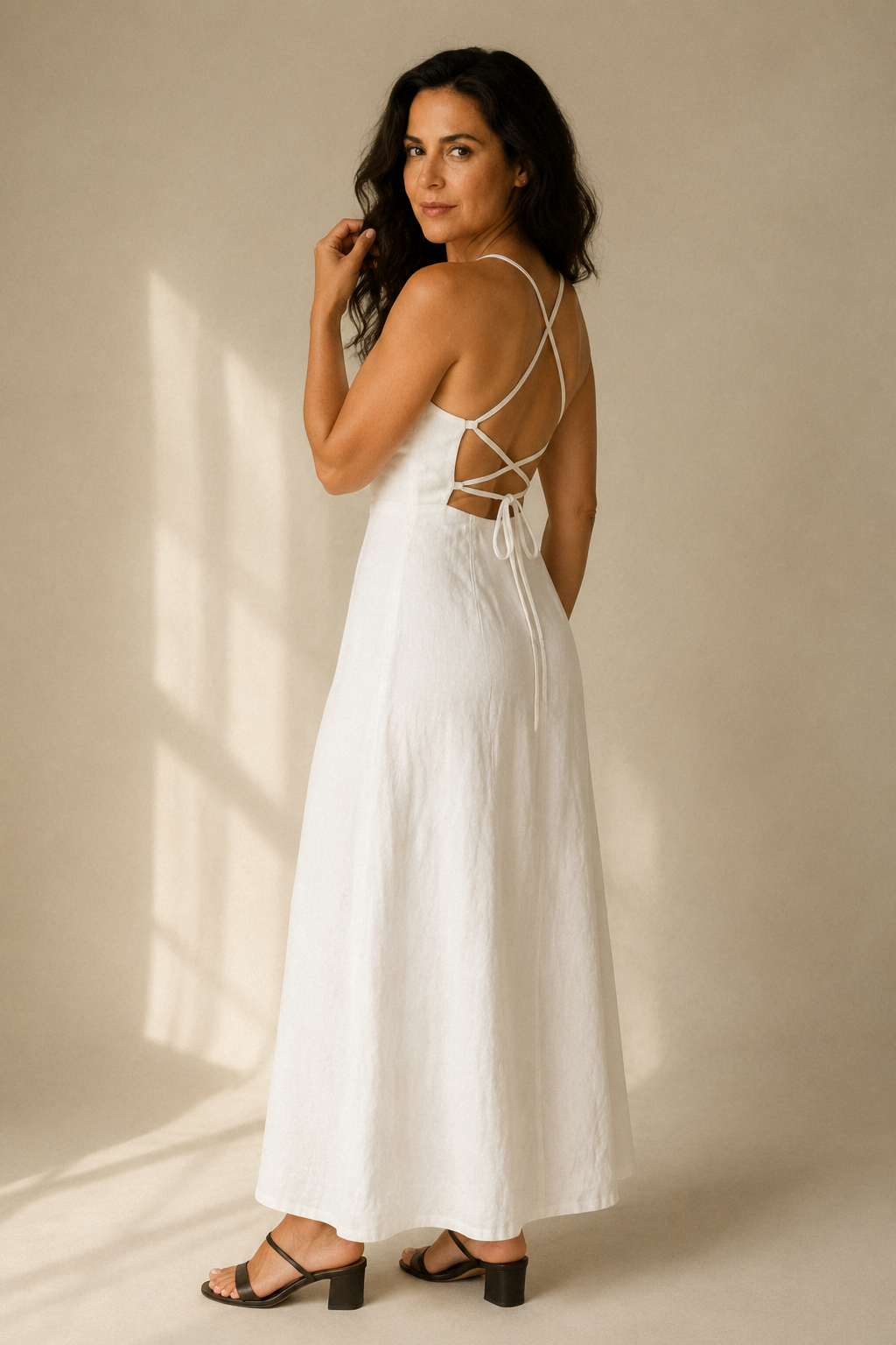 White linen a-line maxi dress, three-quarter view, open back and flowing skirt