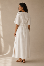 White linen wrap maxi dress, back view, tied waist and skirt fall