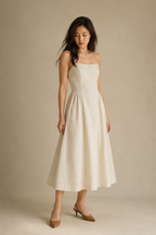 Ivory linen a-line midi dress, three-quarter view, deep scoop back, thin straps, gathered skirt