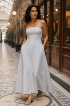 Light grey linen a-line midi dress, lifestyle, coastal ease in warm sunlight