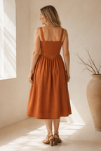 Rust linen a-line midi dress, back view, structured bodice and gathered skirt