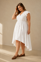 White linen a-line midi dress, three-quarter view, high-low hem and flowing skirt