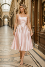 Light pink silk a-line midi dress, lifestyle, twirling on a light-filled afternoon