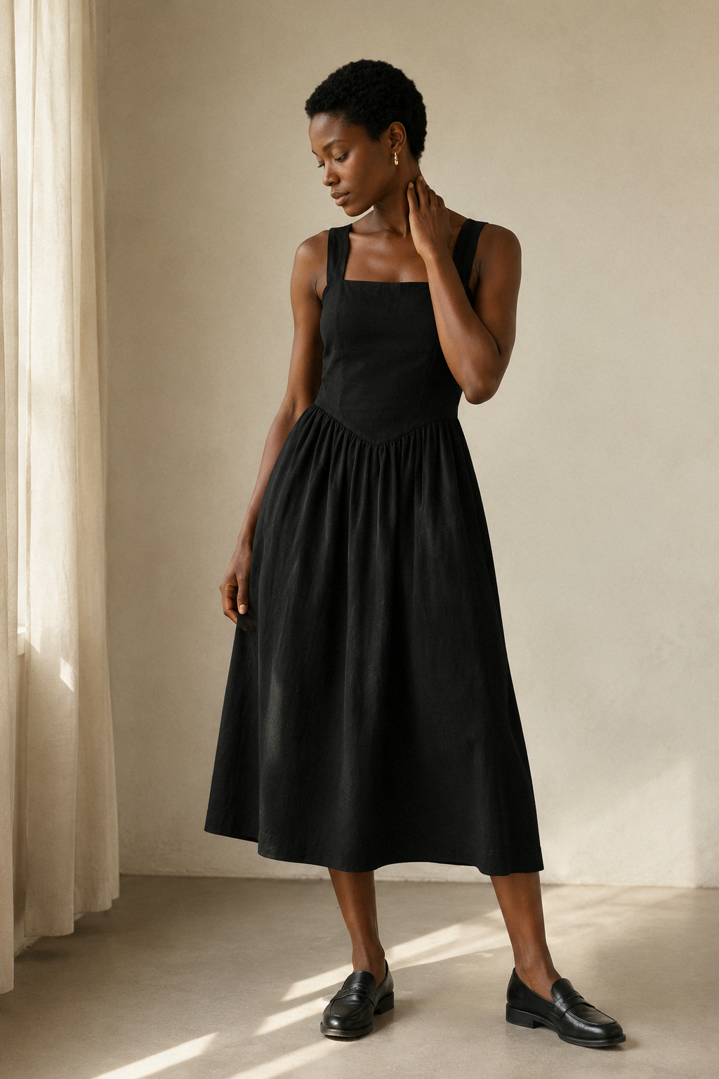 Black linen a-line midi dress, three-quarter view, structured top and gathered skirt