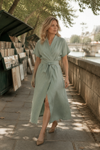 Sage green linen wrap midi dress, lifestyle, quiet morning light, relaxed posture