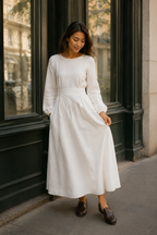 White linen a-line midi dress, front view, round neckline, long sleeves, waist sash