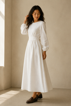 White linen a-line midi dress, three-quarter view, flowing skirt, draped waist, long sleeves