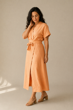 Peach linen wrap midi dress, three-quarter view, wrap tie detail and flowing skirt