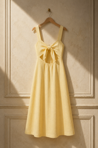 Butter yellow linen a-line midi dress, hanging on wooden hanger against plaster wall