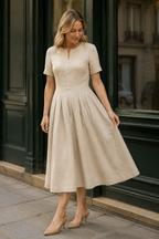 Beige linen a-line midi dress, front view, round neckline, short sleeves, pleated skirt