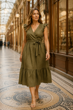 Olive green linen tiered midi dress, lifestyle, walking indoors, soft window light