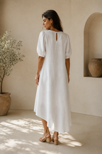 White linen high-low midi dress, back view, softly draped back, comfortable fit