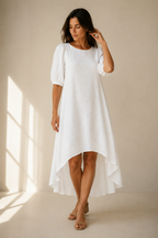 White linen high-low midi dress, full front view, relaxed silhouette, flowing linen fabric