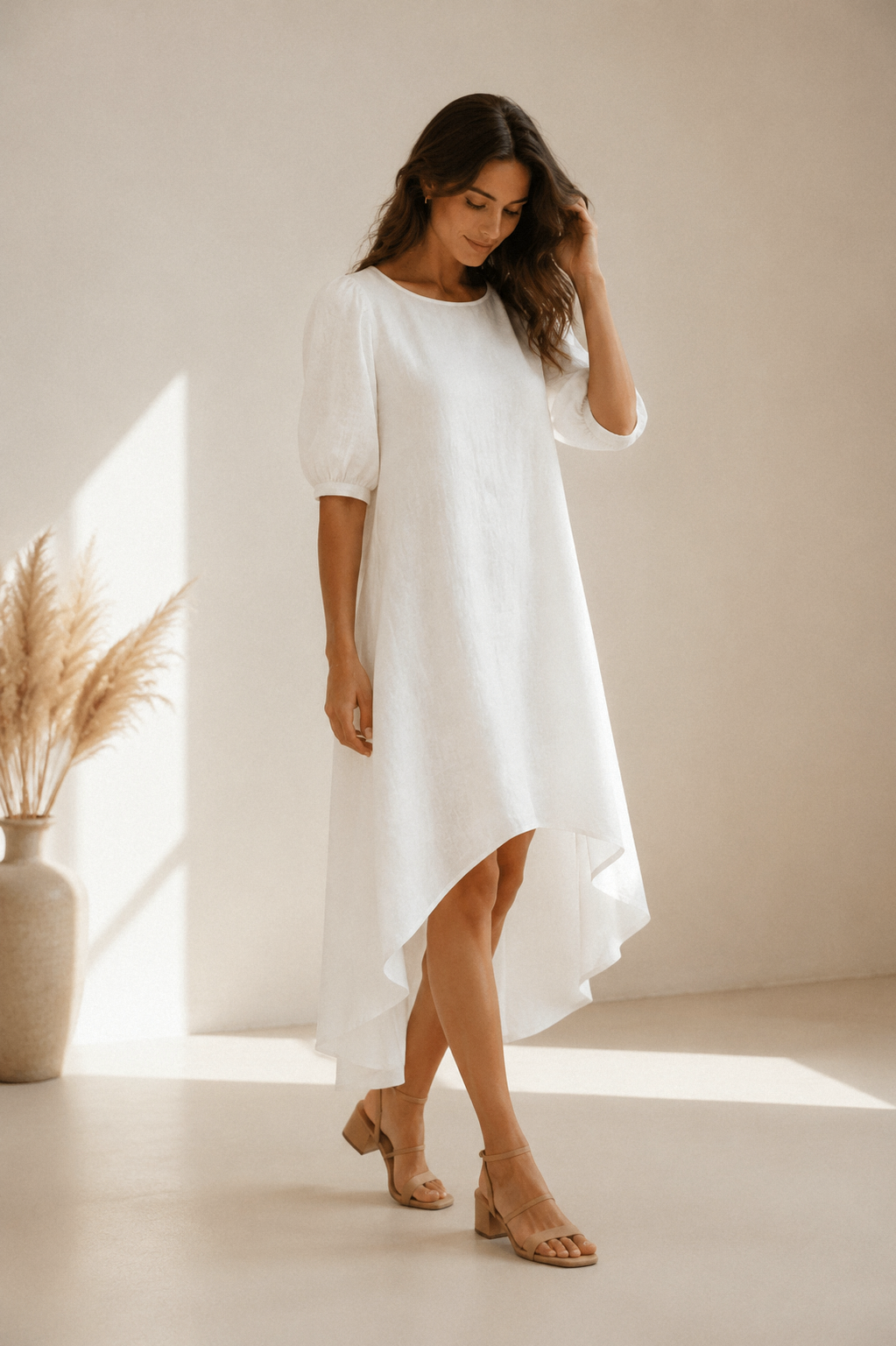 White linen high-low midi dress, three-quarter view, asymmetrical hemline, gentle fabric drape